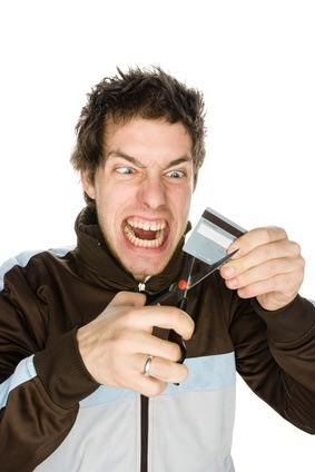 Young male about to cut a credit card on a white background