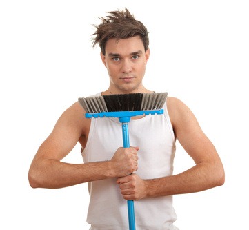 serious young man in casual shirt with sweeping brush