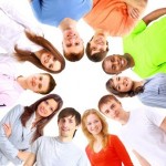 Low angle view of happy men and women standing together in a circle 