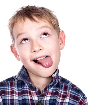 Closeup portrait of a mischief boy showing his tongue