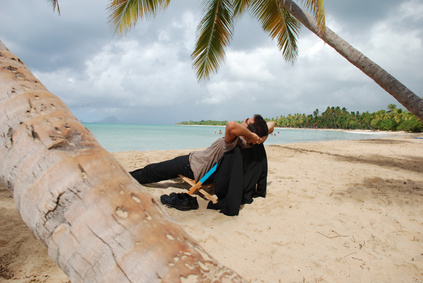 Homme en costume se reposant  l'ombre des cocotiers